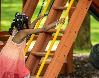 Little Girl Climbing up Playset Ladder Holding on to 62